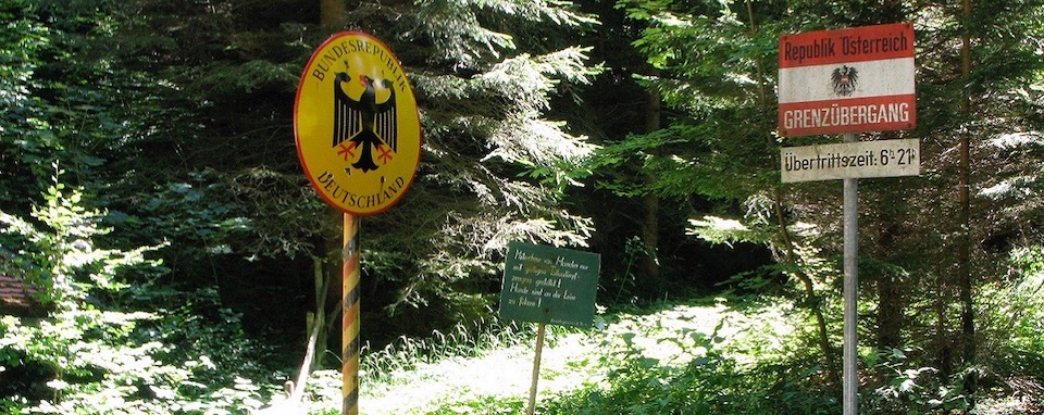 Schilder im Wald markieren die Perimeterkontrolle an der Grenze zwischen der Bundesrepublik Deutschland und der Republik Österreich