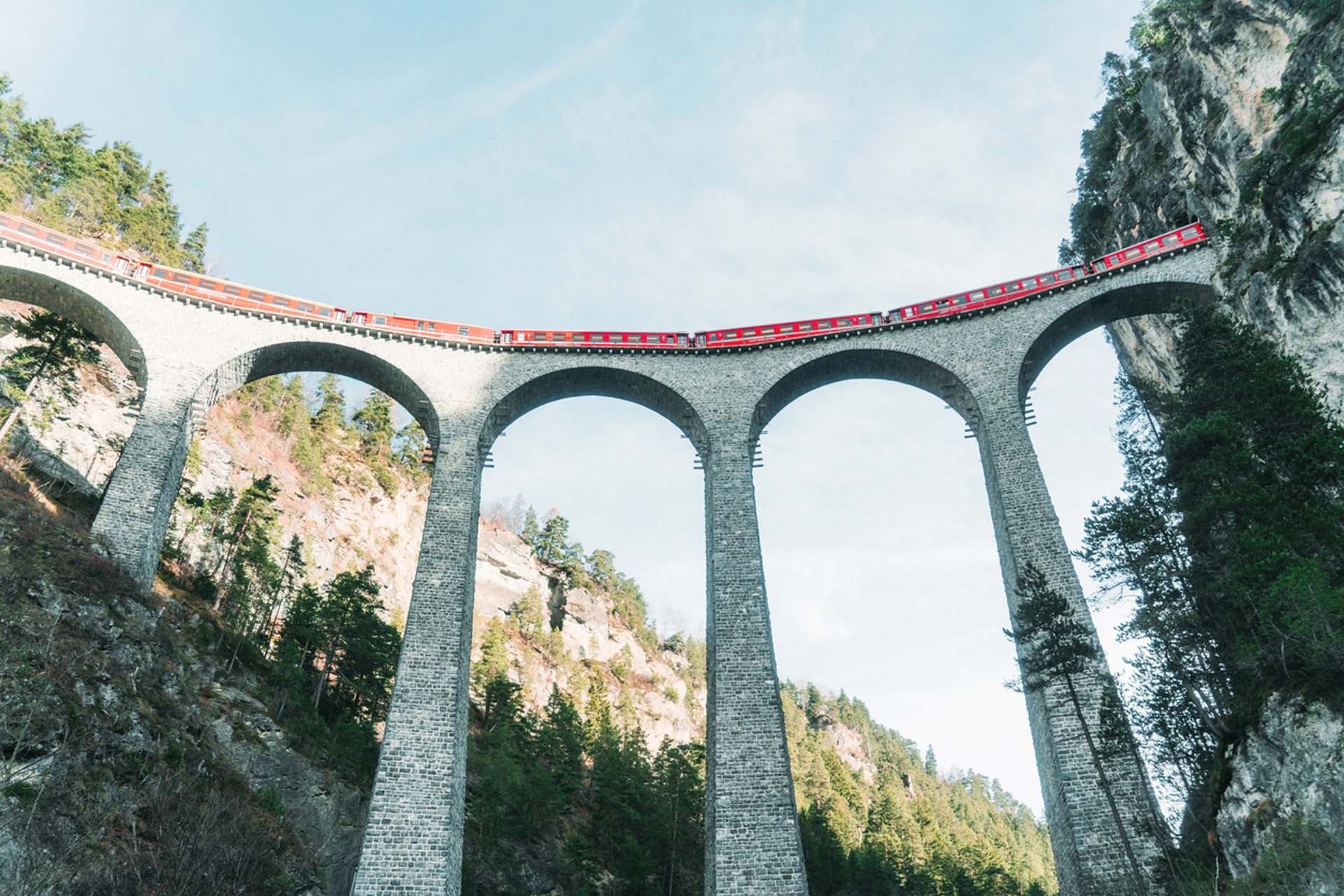 Zug überquert historische Steinbogenbrücke mit Strukturüberwachung zur Gewährleistung von Stabilität und Sicherheit.